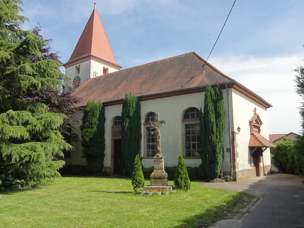 Photographie professionnelle d'une fresque murale de Jako Custom r&eacute;alis&eacute;e &agrave; Geudertheim ou dans une commune alsacienne proche, montrant un travail de graffiti/art urbain de qualit&eacute; professionnelle sur la fa&ccedil;ade d'un b&acirc;timent local. L'image doit capturer la fresque dans son int&eacute;gralit&eacute;, bien &eacute;clair&eacute;e, avec en arri&egrave;re-plan l'architecture alsacienne caract&eacute;ristique du village (b&acirc;timents typiques, architecture r&eacute;gionale). La sc&egrave;ne doit clairement illustrer l'intervention locale de l'artiste sur le territoire alsacien.