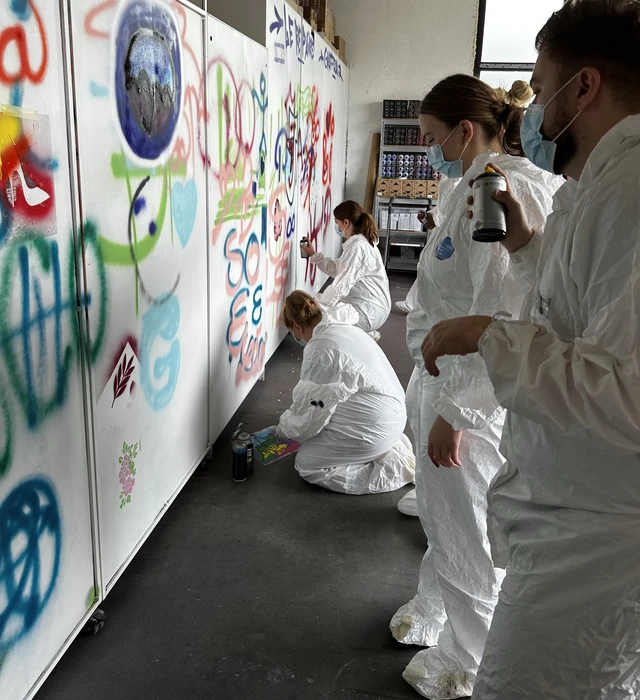 Peinture d'homme anonyme avec brosse sur le mur du bâtiment à l'extérieur