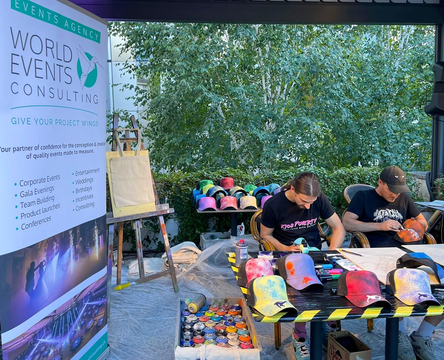 Photographie d'un événement d'entreprise montrant une ambiance festive et collaborative : des participants en tenue professionnelle casual circulant devant ou autour d'une fresque murale finalisée colorée et imposante, certains prenant des photos de l'œuvre avec leur téléphone, d'autres engagés dans des conversations. L'atmosphère doit être celle d'une célébration post-création, avec une lumière naturelle ou professionnelle, dans un cadre intérieur ou extérieur moderne et soigné, montrant l'impact social et professionnel d'une œuvre de Jako Custom lors d'un événement corporate.