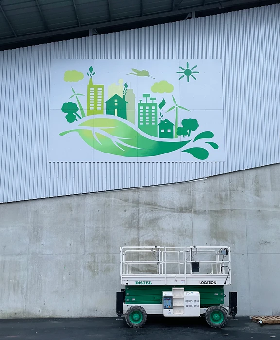 Photographie d'une fresque murale en cours de réalisation ou finalisée dans un espace professionnel (couloir d'entreprise, façade commerciale ou local professionnel), montrant un motif artistique coloré et détaillé, peint à la main ou avec des techniques de street art, avec un rendu de qualité professionnelle et un évident travail technique.