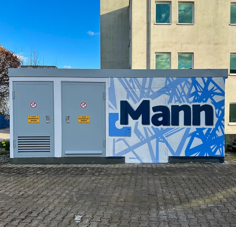 Scène urbaine stylisée représentant une rangée de bâtiments commerciaux et résidentiels avec clocher d'église au centre