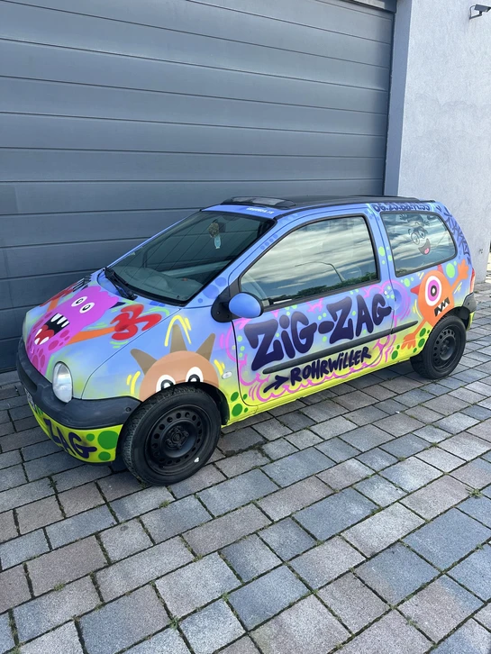 Vue rapprochée d'un homme qui peint une voiture en utilisant un spray de peinture